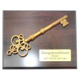 Übergabeschlüssel auf Holztafel mit Text- und Logogravur...